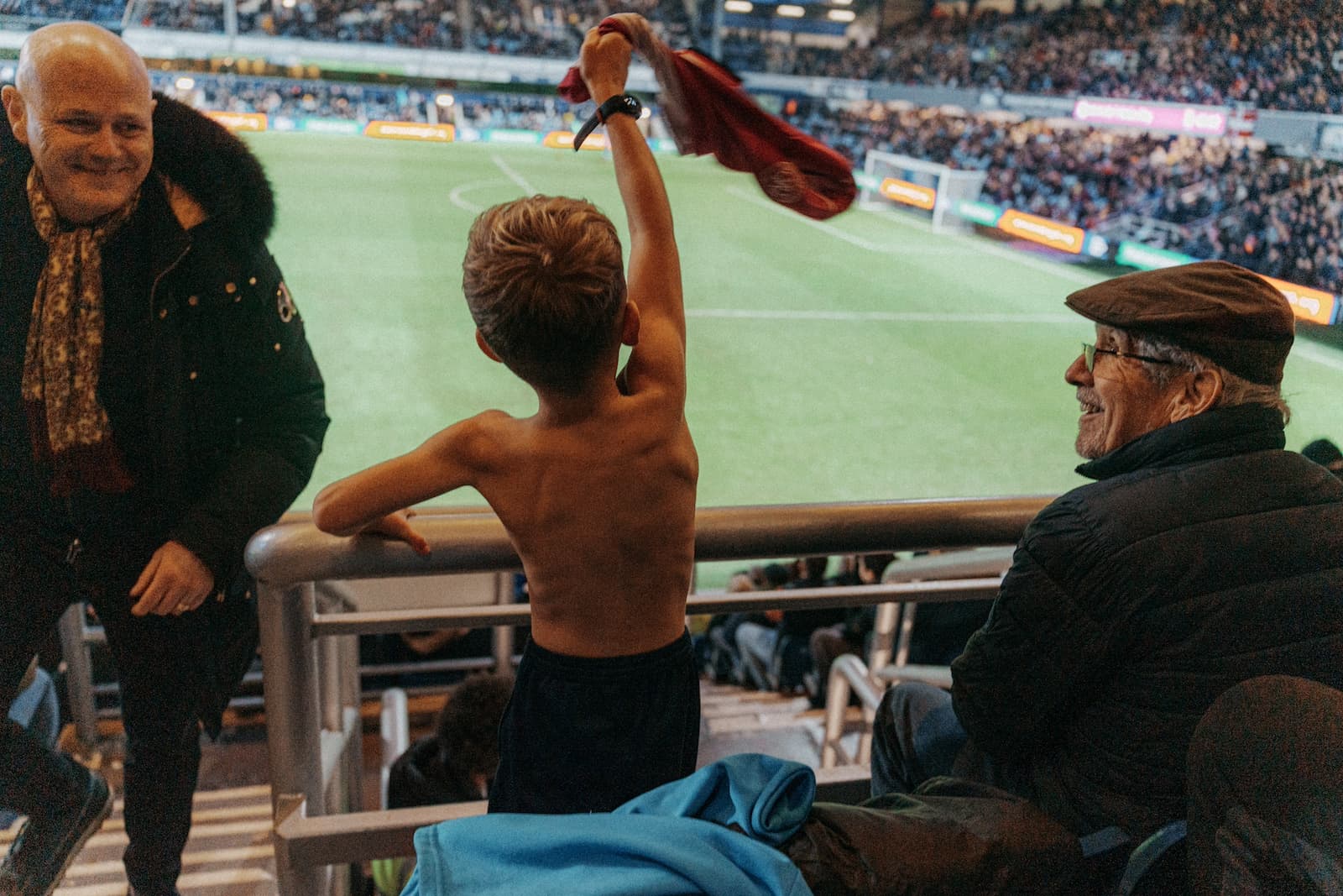 A young QPR fan swinging his shirt around